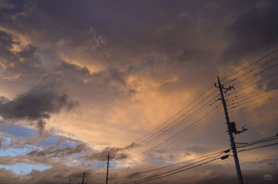 Low angle view of silhouette electricity pylon against sky during sunset