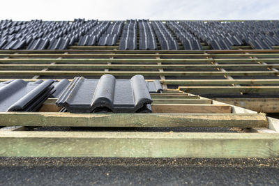 Roof ceramic tile arranged in packets on the roof on roof battens. laying tiles on a boarded roof.