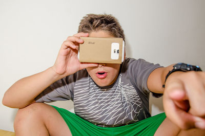 Close-up of boy gesturing while wearing virtual reality simulator