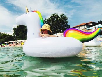 Woman with inflatable ring swimming in sea at beach