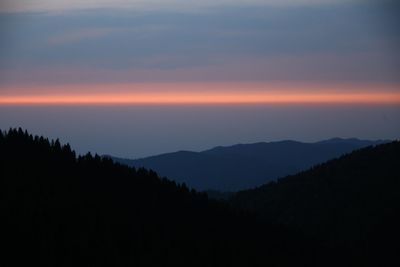 Scenic view of silhouette mountains against sky at sunset