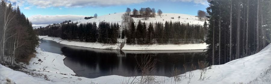 Panoramic view of frozen lake against sky