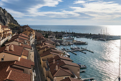 High angle view of buildings by sea against sky