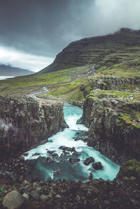 Scenic view of waterfall against sky