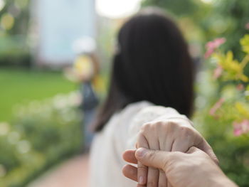 Rear view of woman hand on plant