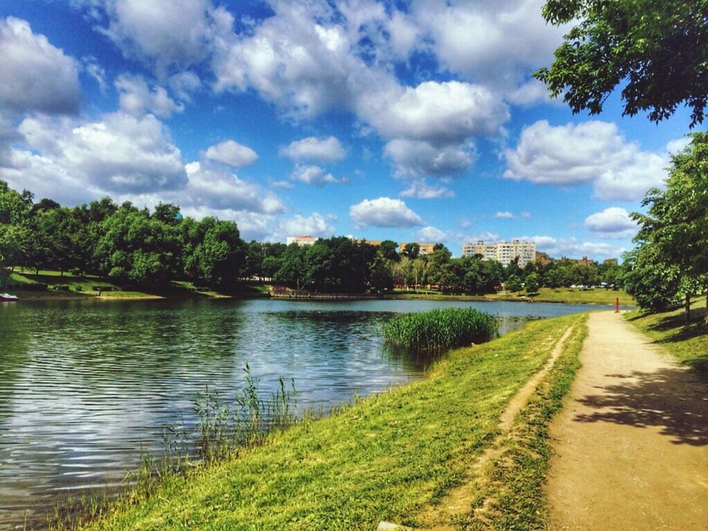 sky, tree, water, tranquil scene, tranquility, cloud - sky, scenics, cloud, lake, beauty in nature, nature, grass, river, growth, cloudy, green color, landscape, idyllic, day, reflection