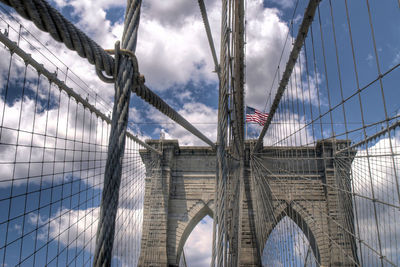 Low angle view of bridge against cloudy sky