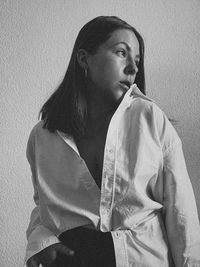 Portrait of young woman standing against wall