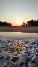 Scenic view of frozen lake against sky during sunset