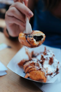 Close-up of hand holding ice cream on table