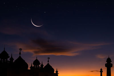 Silhouette mosques with crescent moon on twilight sky