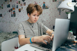 Teenager schoolgirl doing homework using a laptop.