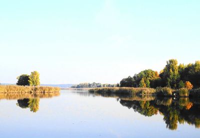 Calm lake against clear sky