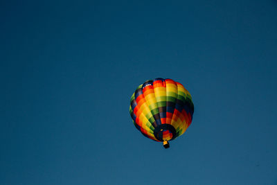 Low angle view of hot air balloon against clear blue sky