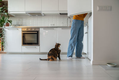 Side view of young woman sitting on floor at home