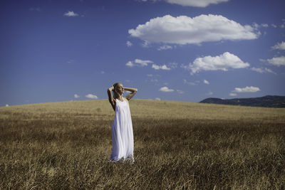 Woman standing on field against sky