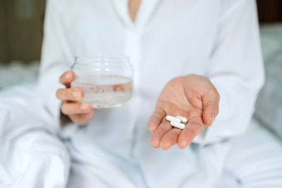 Midsection of doctor holding dentures