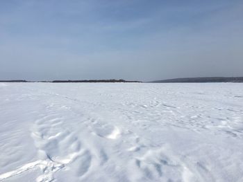 Scenic view of snow covered land against sky