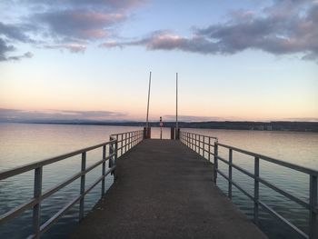 Pier over sea against sky during sunset