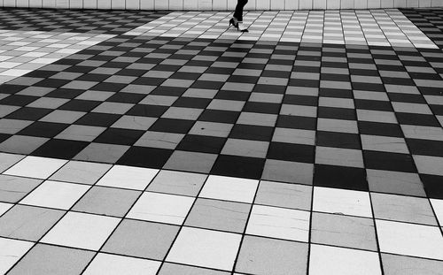 Low section of woman walking on tiled floor