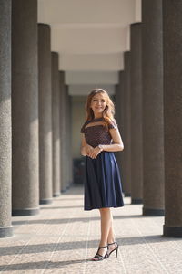 Beautiful woman posing between stone pillars