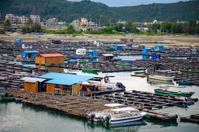 High angle view of boats moored at harbor by buildings