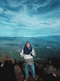 Full length of man standing on mountain against sky