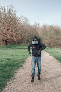 Full length portrait of man running wtih mask  on street