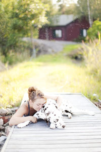 Woman with dalmatian dog at jetty