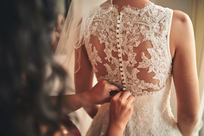 Midsection of bride holding bouquet