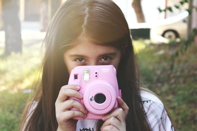 Portrait of girl holding camera