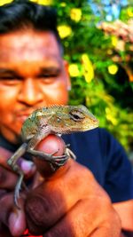 Close-up of man holding bearded dragon