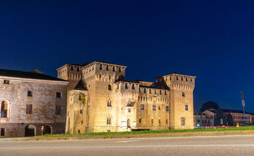 Old building against blue sky at night