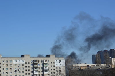 There is black smoke from a rocket or bomb explosion in a city during a war
