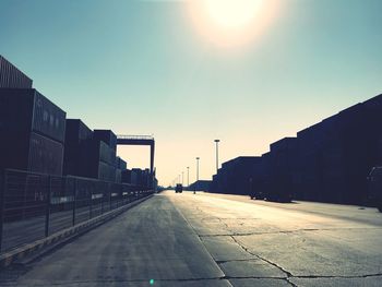 Empty road amidst buildings against sky