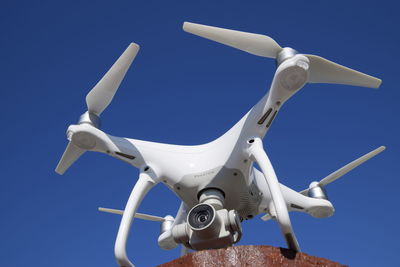 Low angle view of camera against clear blue sky