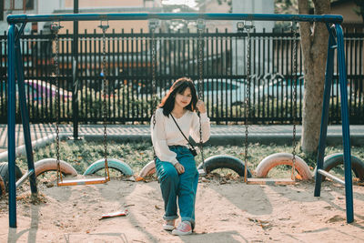 Full length of woman looking at fence