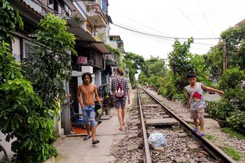 REAR VIEW OF PEOPLE WALKING ON STREET