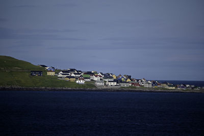 Scenic view of sea by buildings against sky