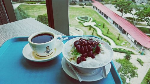 High angle view of chendol served in bowl with black coffee on tray