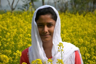 Portrait of mid adult woman against yellow flower