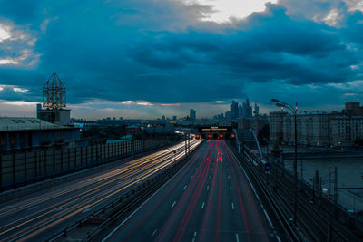 High angle view of light trails on road against cloudy sky