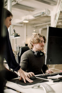 Female entrepreneur with coworker sitting at workplace