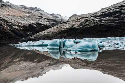 Scenic view of iceland glacier against sky and mountain during winter with reflections