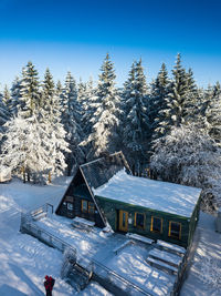 Snow covered houses and trees against clear sky