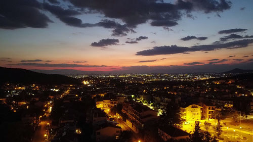 High angle view of illuminated buildings against sky at sunset