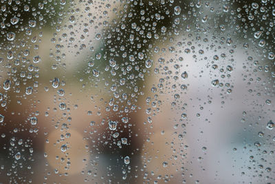 Full frame shot of wet glass window during rainy season