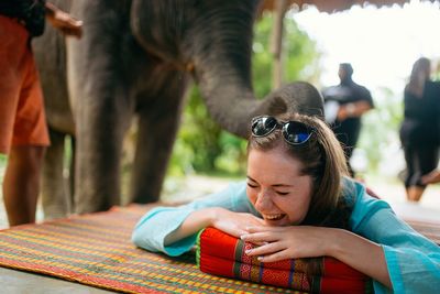 Portrait of young woman outdoors massage elefant