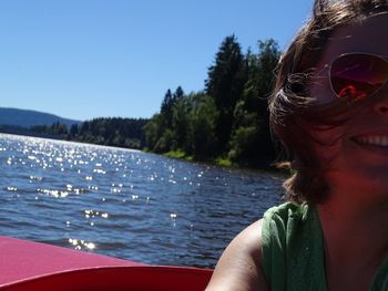 Close-up of happy woman on boat in river against sky during sunny day
