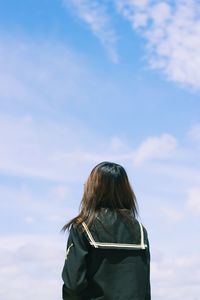Rear view of woman standing against sky